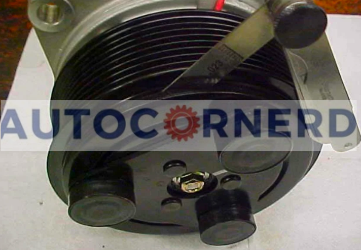 Feeler gauge positioned in the gap of an A/C compressor clutch assembly.