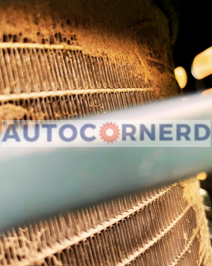 Air-conditioning condenser fins covered with accumulated dirt and debris.