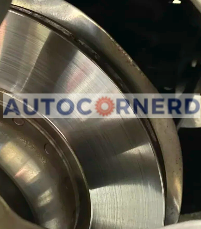 Brake rotor with a metal backing plate visible behind its edge.