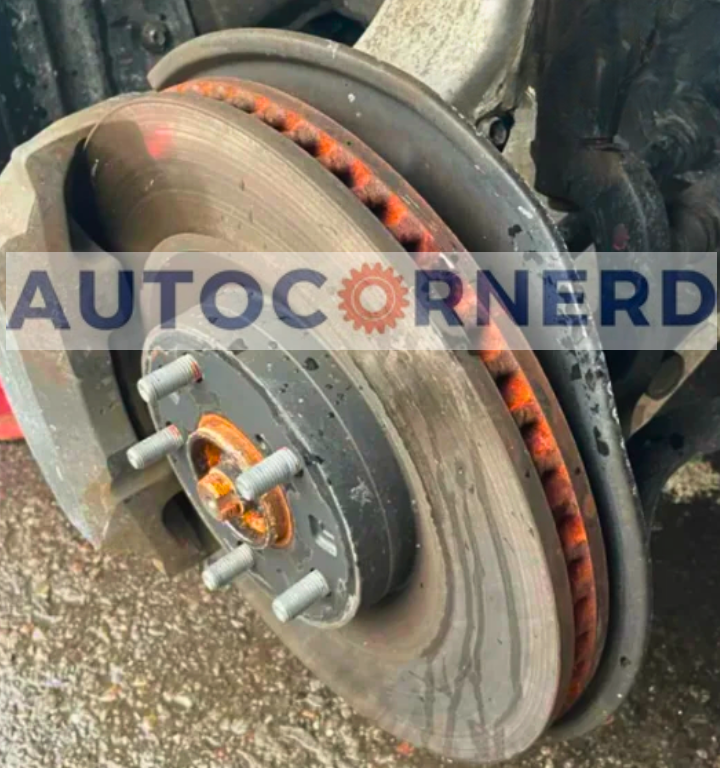 Brake rotor and nearby dust shield viewed with the wheel removed.