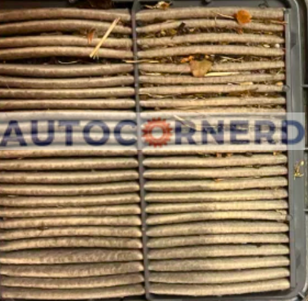 Pleated engine air filter with visible dirt and small debris.