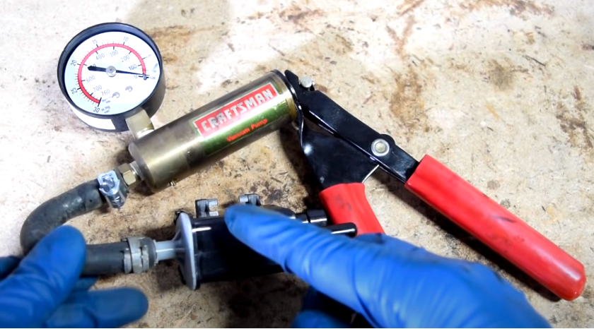EVAP purge valve connected to a hand-operated vacuum tester.