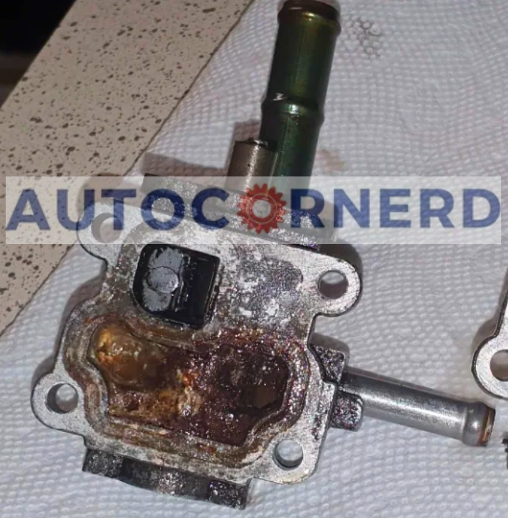Removed idle-air-control valve with deposits and corrosion on its metal body.