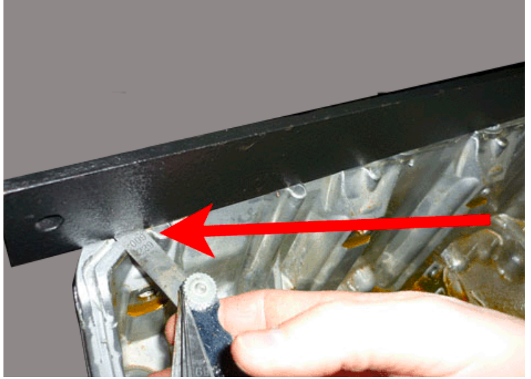 Straightedge and feeler gauge positioned against an oil-pan sealing surface.