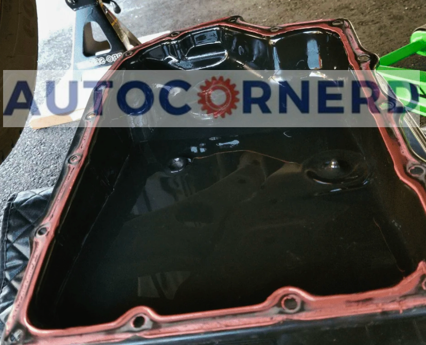 Removed transmission pan with fluid inside and a perimeter gasket visible.