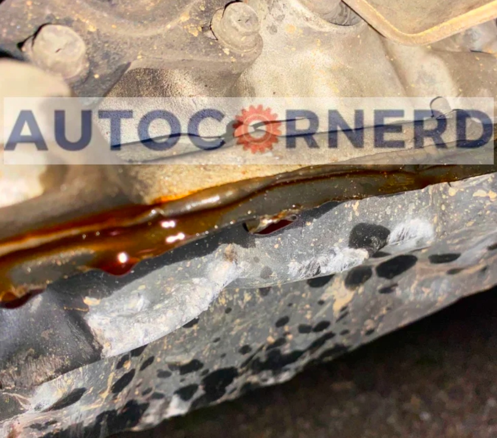 Transmission-pan sealing edge with fluid visible along the joint.