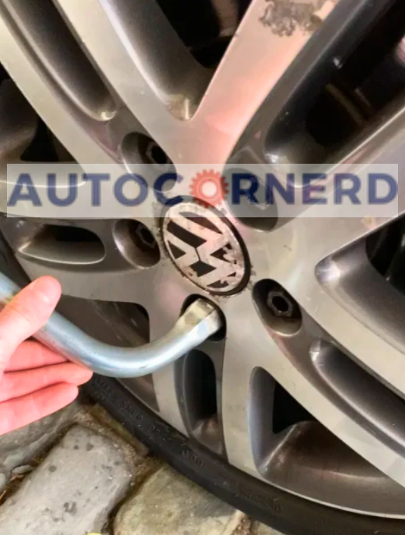 Vehicle wheel fasteners being checked with a hand tool.