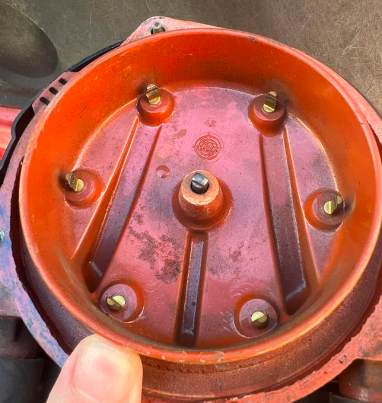Inside view of a worn distributor cap with corroded contact points, which could be responsible for a flashing check engine light due to ignition issues.