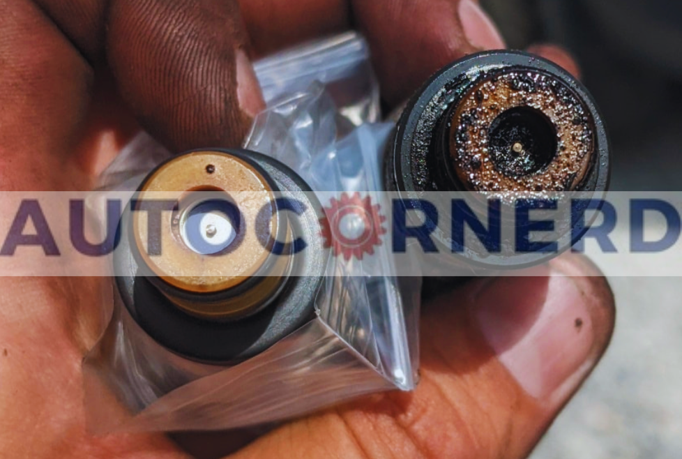  A close-up view of a person’s hand holding two fuel injectors, one new and the other affected by bad fuel, showcasing the contrast between their conditions. The new injector is encased in a clear plastic bag, its golden top gleaming, indicative of its pristine condition and readiness to deliver the appropriate amount of fuel efficiently. Adjacent to it, the bad injector reveals a corroded and clogged surface, a direct result of bad fuel injectors failing to deliver an appropriate amount of fuel.