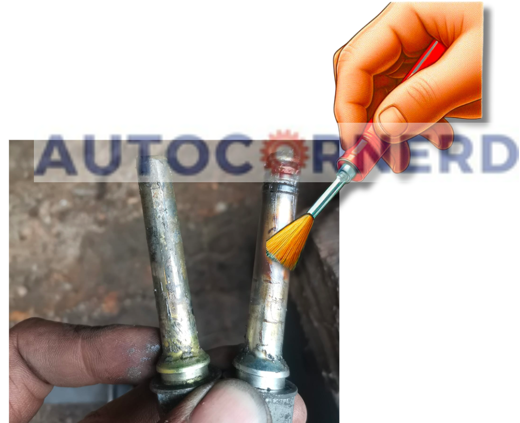 A detailed view of a person holding two brake caliper pins, showcasing the before and after effects of cleaning and lubricating. The pin on the left is visibly dirty and corroded, while the one on the right gleams, having been thoroughly cleaned and lubricated to eliminate squeaking noises. The process is essential for maintaining optimal brake performance and ensuring safety.