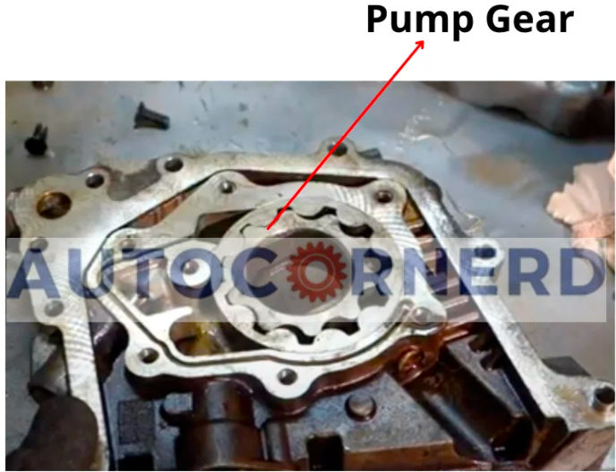 Open view of an engine's oil pump gear, a critical component in maintaining oil circulation, where failure can result in low oil pressure, particularly at idle speeds.