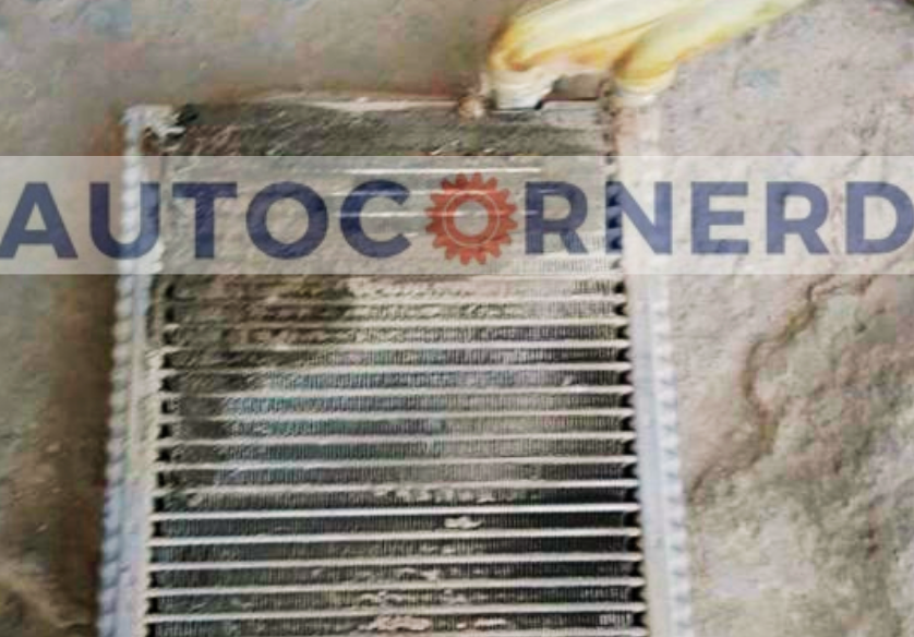A car's evaporator core with visible signs of mold and debris, which can cause a strong vinegar-like odor when the AC system is running.