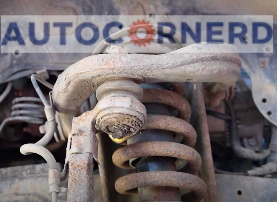 A close-up view of a vehicle’s suspension system reveals signs of ball joints binding not allowing steering wheel to center. The rusty and dirty ball joint is a potential cause of steering problems and safety hazards. 